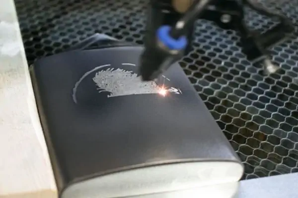 عکس دستگاه حک لیزری در حین حک روی بطری فلزی