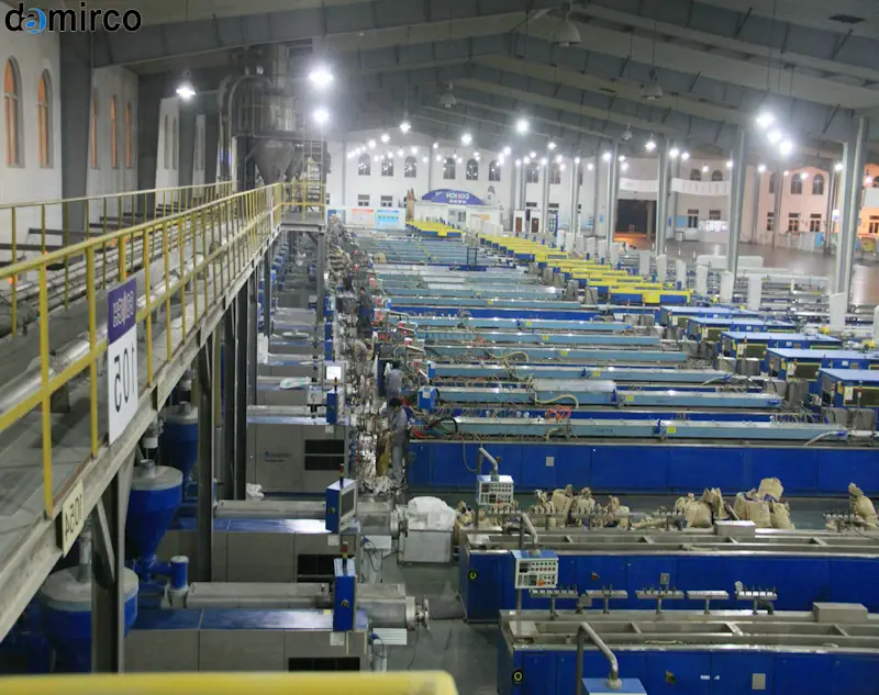 نمایی از خط تولید پروفیل UPVC در حال کار با تمرکز بر اکسترودر و نور پس زمینه سبز که نماد بهینه‌سازی انرژی است.