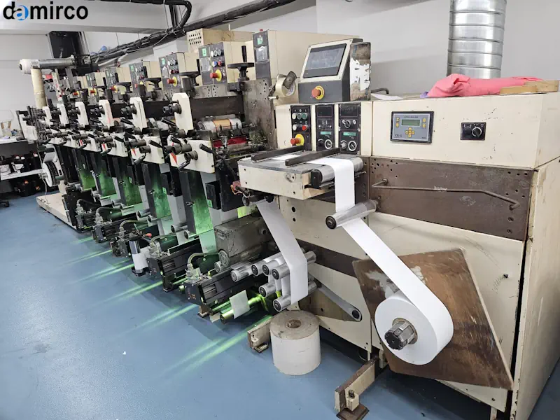 دستگاه چاپ فلکسو صنعتی در حال کار با رول‌های سوبسترا و جوهر برای چاپ چند رنگ با کیفیت بالا.