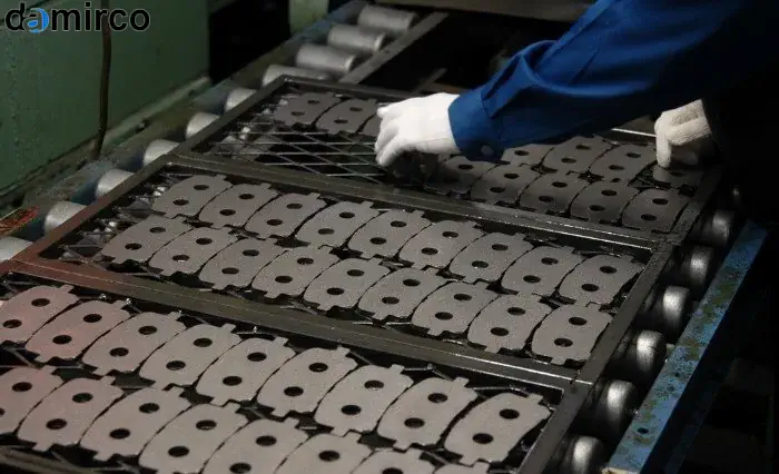 یک خط تولید پیشرفته لنت ترمز در حال کار با ماشین‌آلات اتوماتیک و رباتیک که استانداردهای کیفیت ISO و IATF 16949 را رعایت می‌کنند