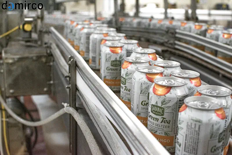 تصویر مقایسه‌ای قوطی‌های آلومینیومی و فلزی روی خط تولید صنعتی