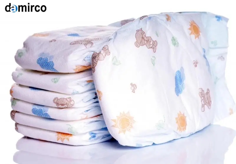 یک خط تولید پیشرفته پوشک بچه در حال کار با اپراتورها و ماشین‌آلات مدرن در یک کارخانه تمیز و نورانی.