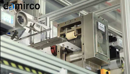 خط تولید پوشک در حال نصب و راه‌اندازی، با مهندسانی که در حال بررسی و تنظیم ماشین‌آلات هستند.