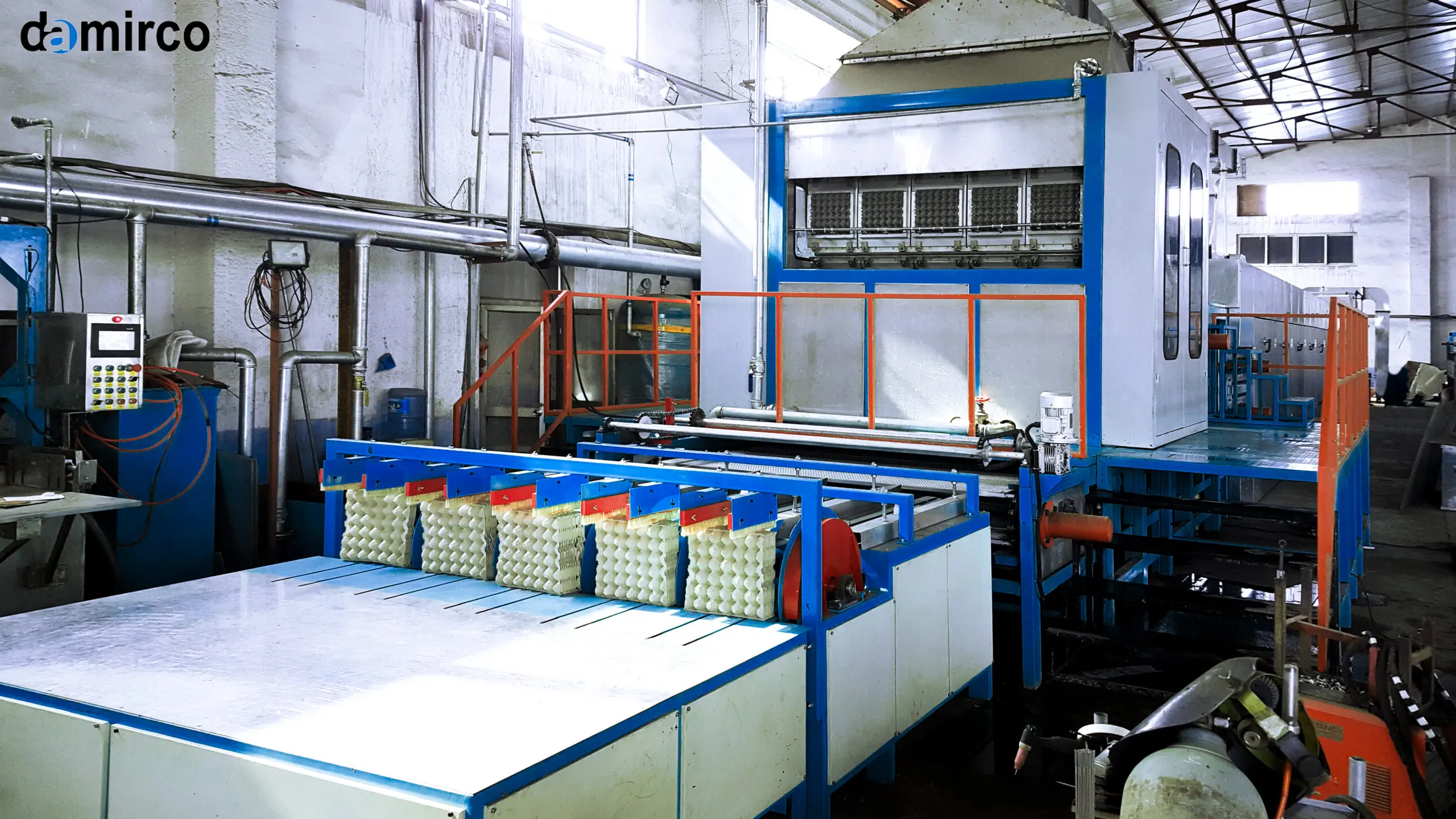 تصویر خط تولید شانه تخم‌مرغ با دستگاه‌های خمیرساز، قالب‌گیر و خشک‌کن. شانه‌های تخم‌مرغ آماده روی نوار نقاله در حال حرکت هستند.