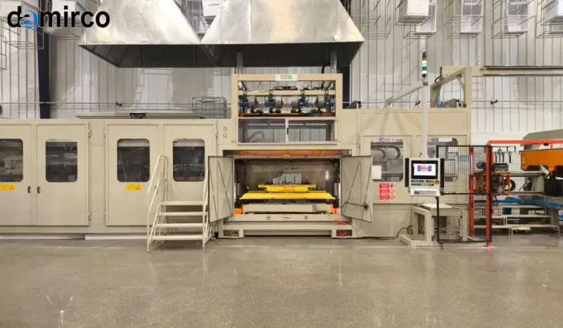 نمای نزدیک از یک دستگاه ترموفرمینگ در حال شکل‌دهی ورق پلاستیکی قرمز رنگ