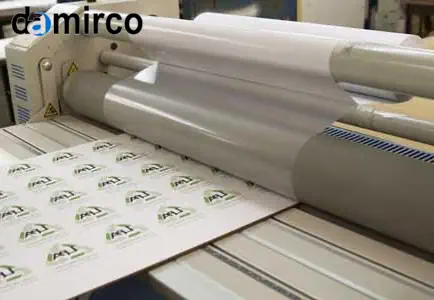 تصویری از یک دستگاه لمینت کاغذ صنعتی در حال لمینت کردن یک پوستر بزرگ