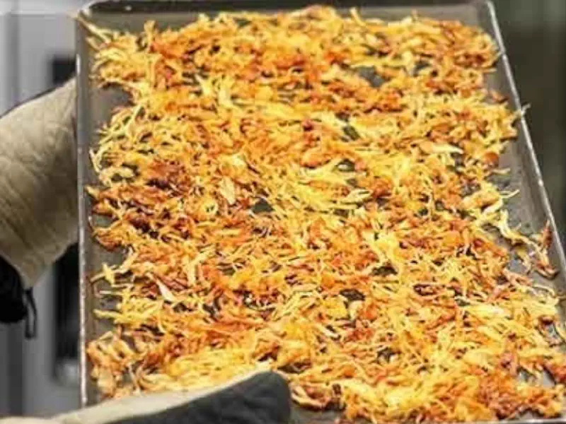 عکس سینی پیاز داغ در دست یک انسان در خط تولید پیاز داغ