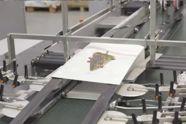 عکس از کیسه پلاستیکی سفید با آرم برگ سبز در وسط در خط تولید اتوماتیک کیسه خرید