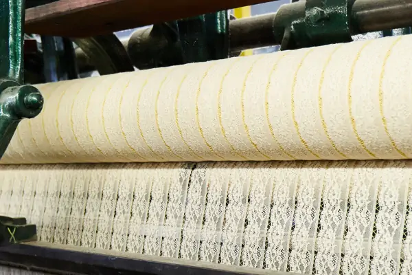 عکس طاقه توری کرم رنگ همراه با دستگاه توری بافی