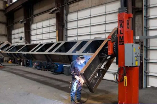 عکس یک آدم در حال جوشکاری و میز چرخان جوشکاری