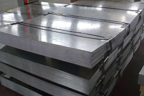 عکس ورق های آهن خاکستری در کارگاه که با طناب پلاستیکی بسته شده اند.